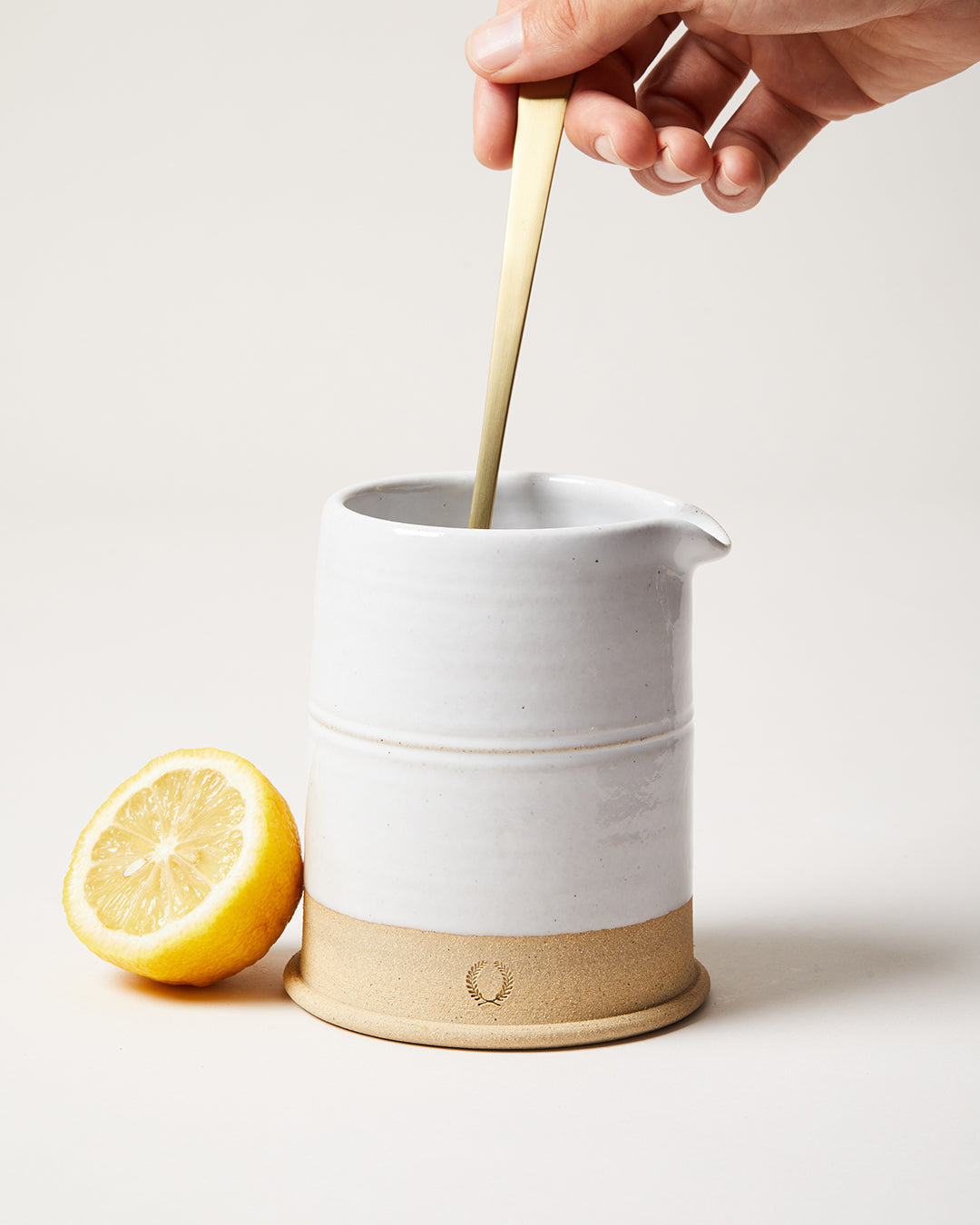 A cocktail being stirred in the white stoneware Countryman Cocktail Beaker