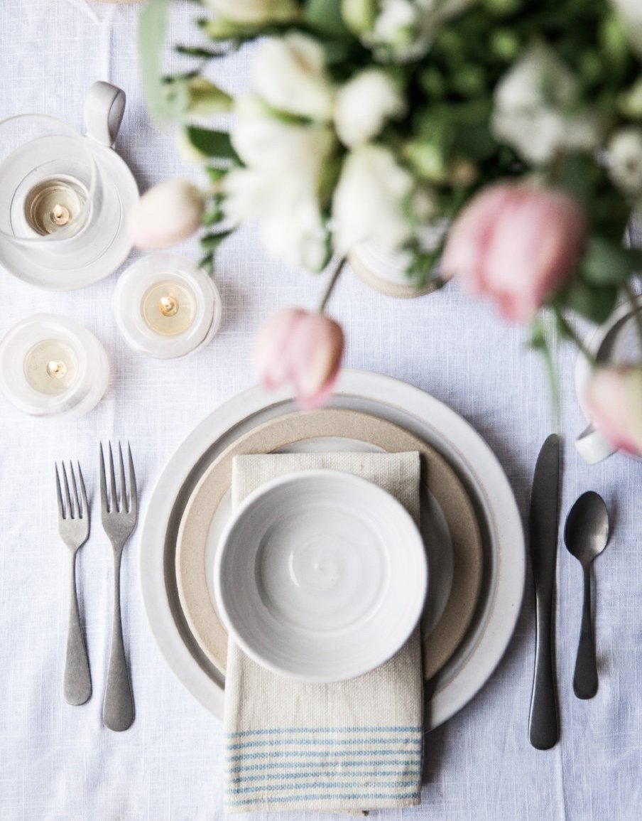 Silo Bowl on a linen napkin with matching stoneware plates in a floral table setting