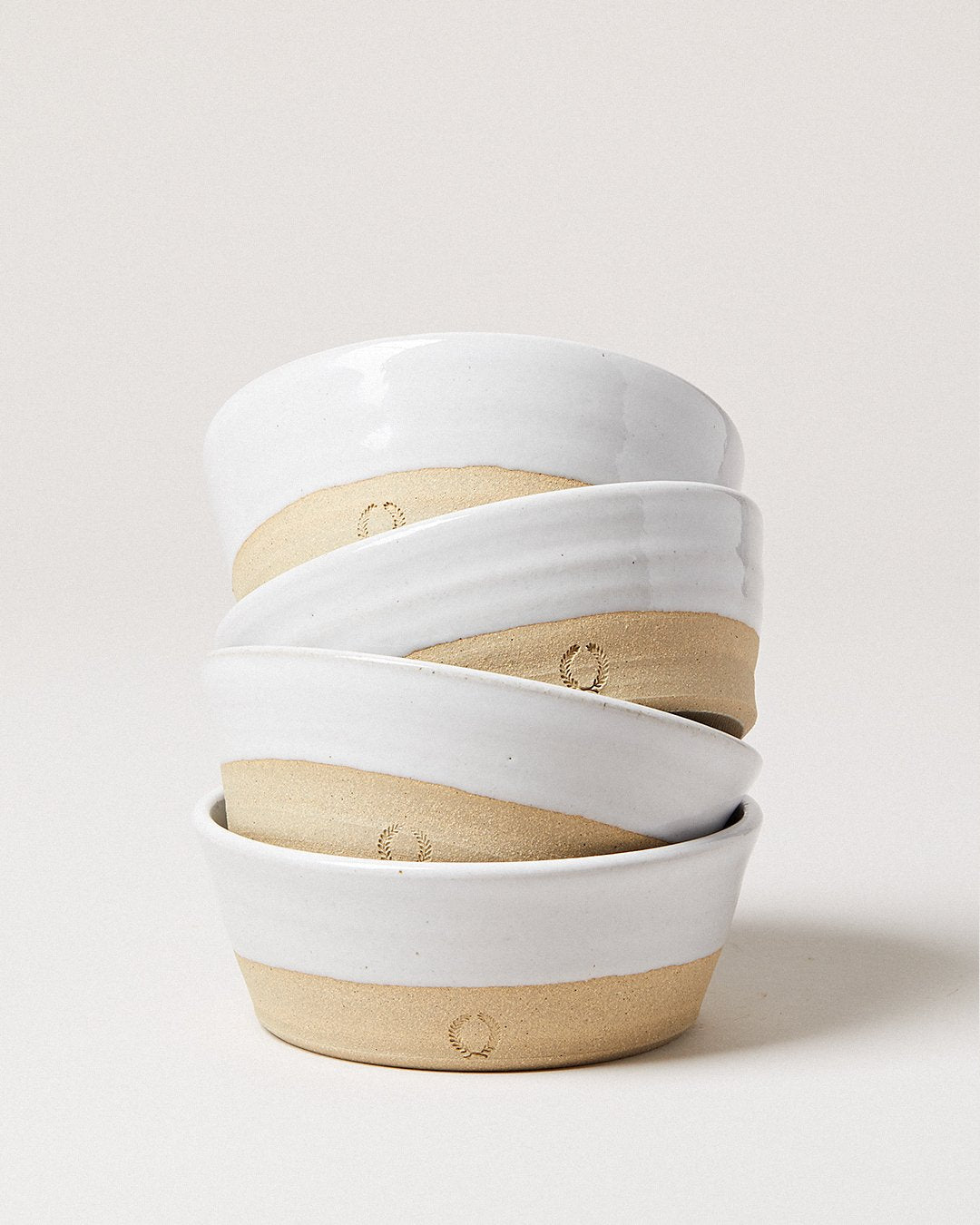 A stack of Farmhouse Pottery Silo Bowls showing the white glaze and clay bases; bowls sold individually
