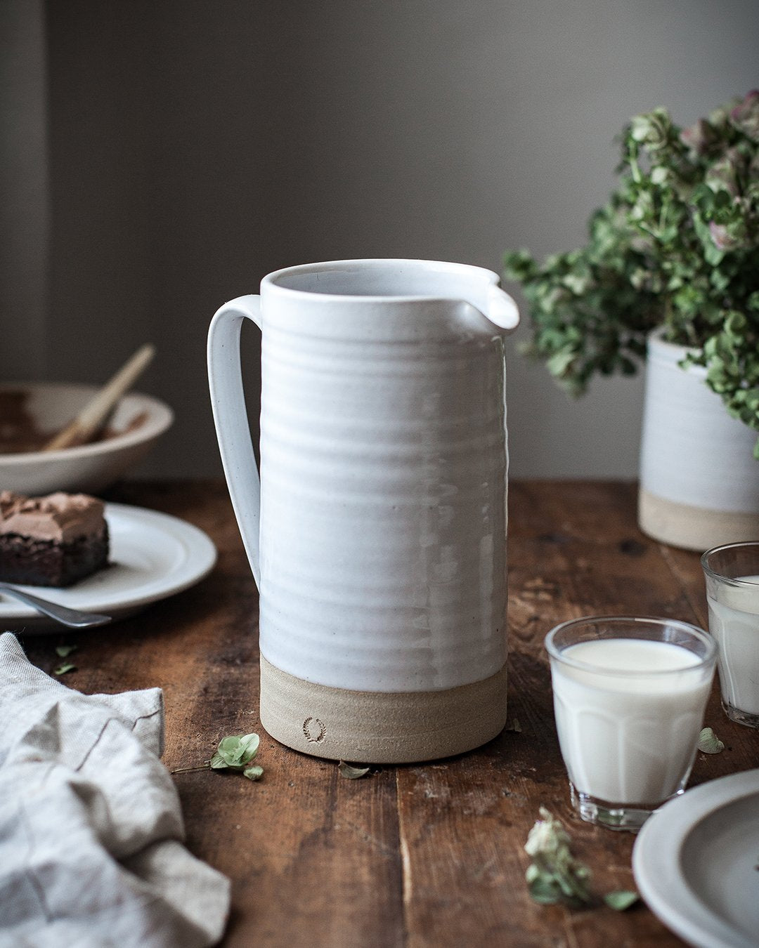 Large Silo Pitcher on a wooden table with glasses of milk and cake; accessories not included