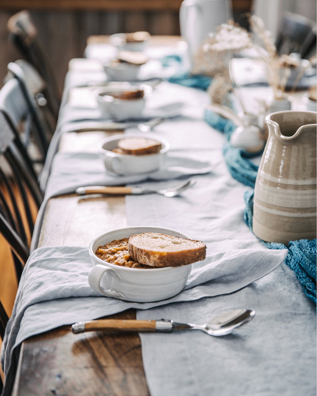 Silo Soup Mugs with soup and bread arranged along a linen-covered dining table