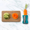 Karoto Julienne with a carrot, decorative carrot curls and thin zucchini strips on a cutting board