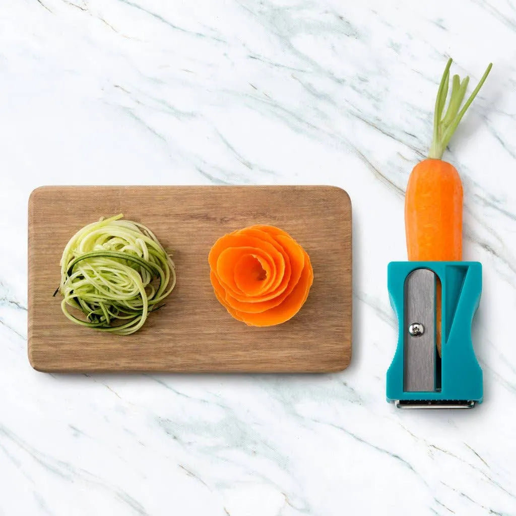Karoto Julienne with a carrot, decorative carrot curls and thin zucchini strips on a cutting board